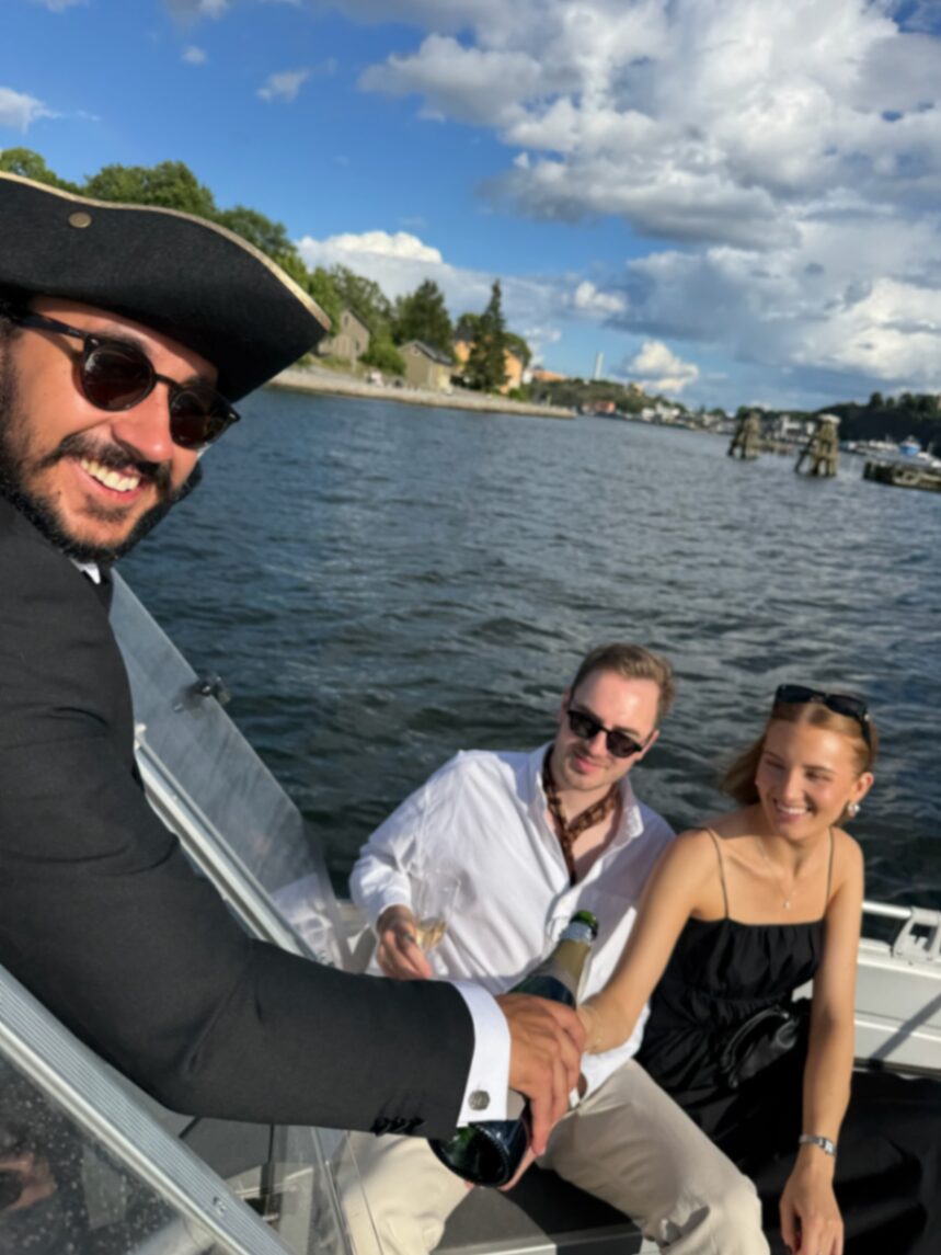 Captain pouring champagne with guests on board